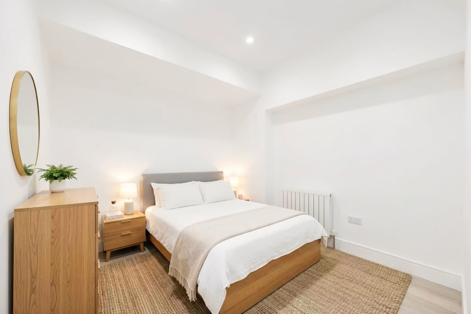 Bedroom with a double bed, oak furniture and a tall white radiator.